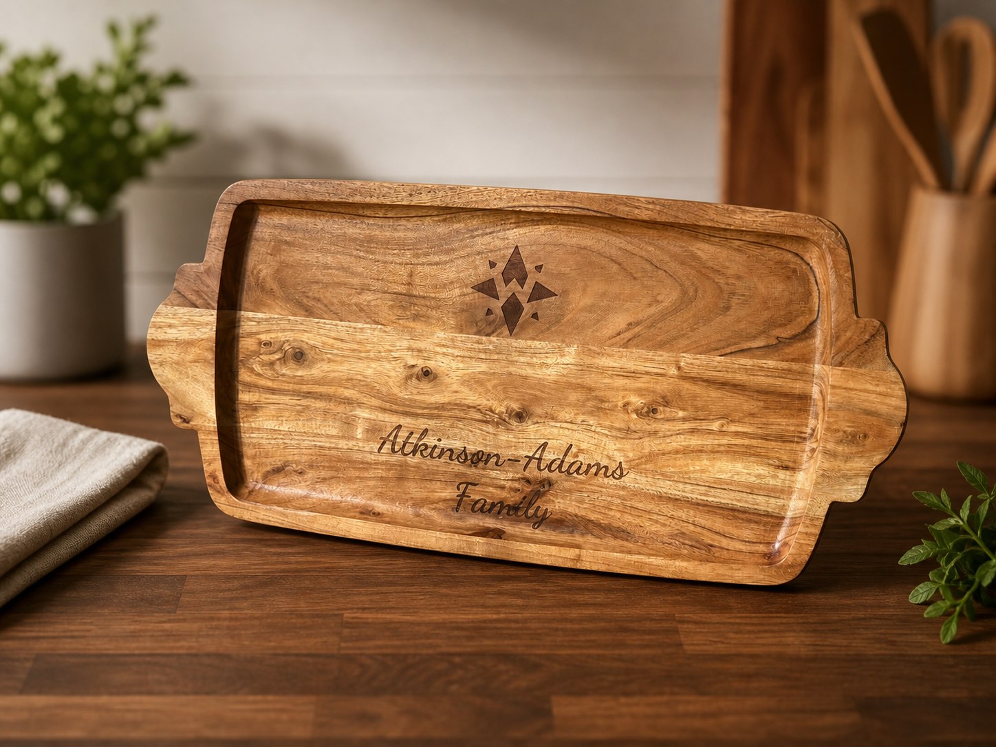 Wood cutting board engraved with Atkinson-Adams Family and a compass mark.