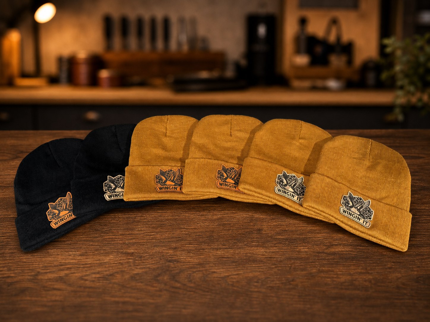 Group of black and gold beanies with Wingin' It patches.