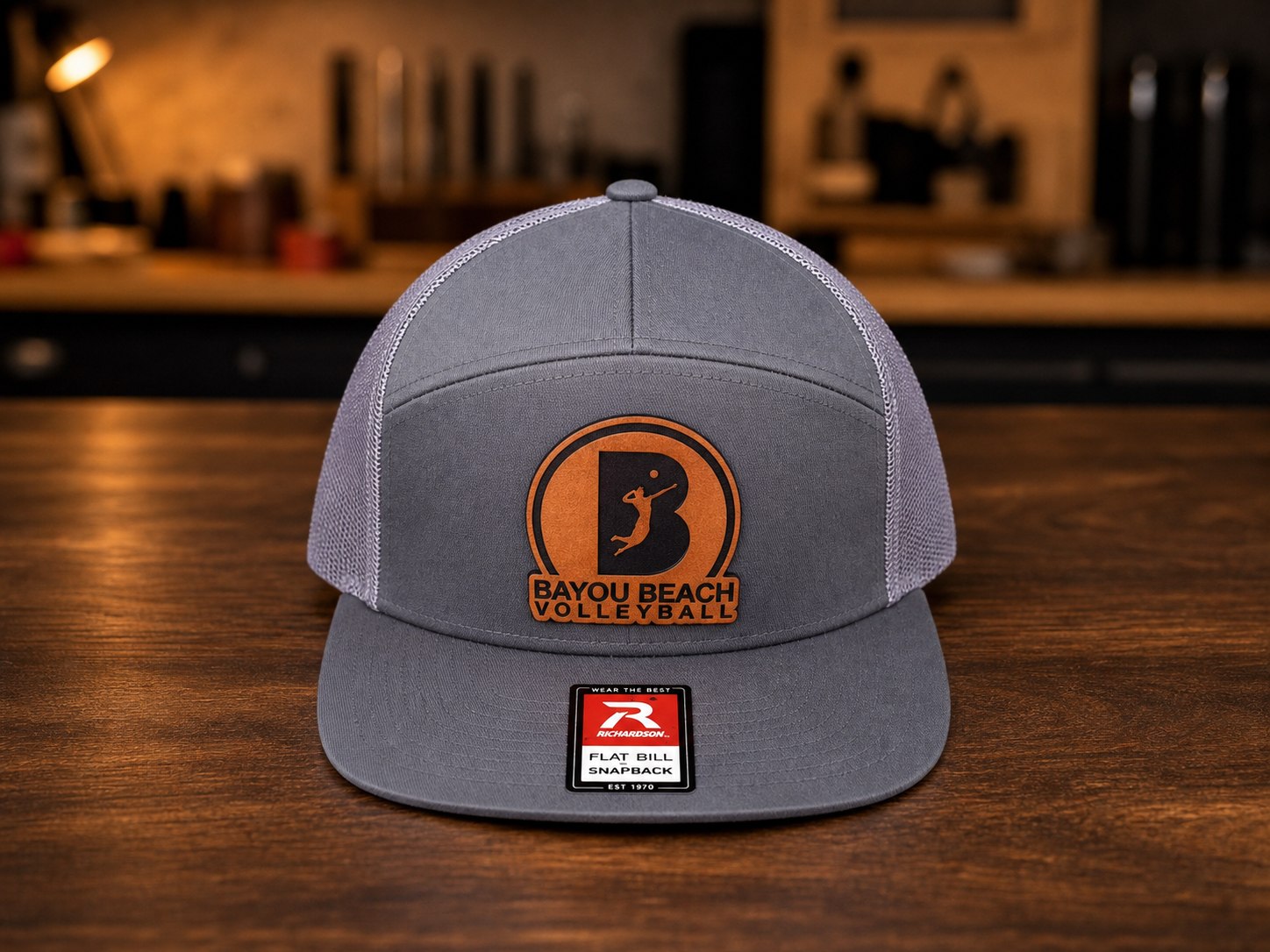 Gray flat bill hat with Bayou Beach Volleyball leather patch.