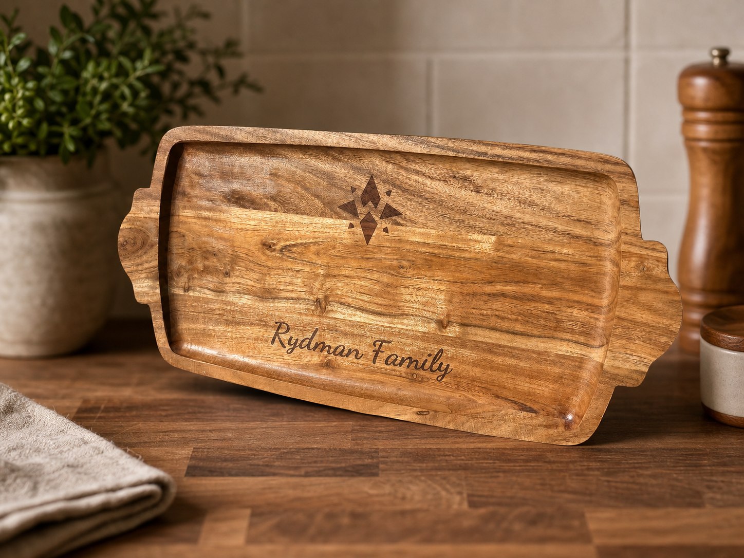 Wood cutting board engraved with Rydman Family and a compass mark.